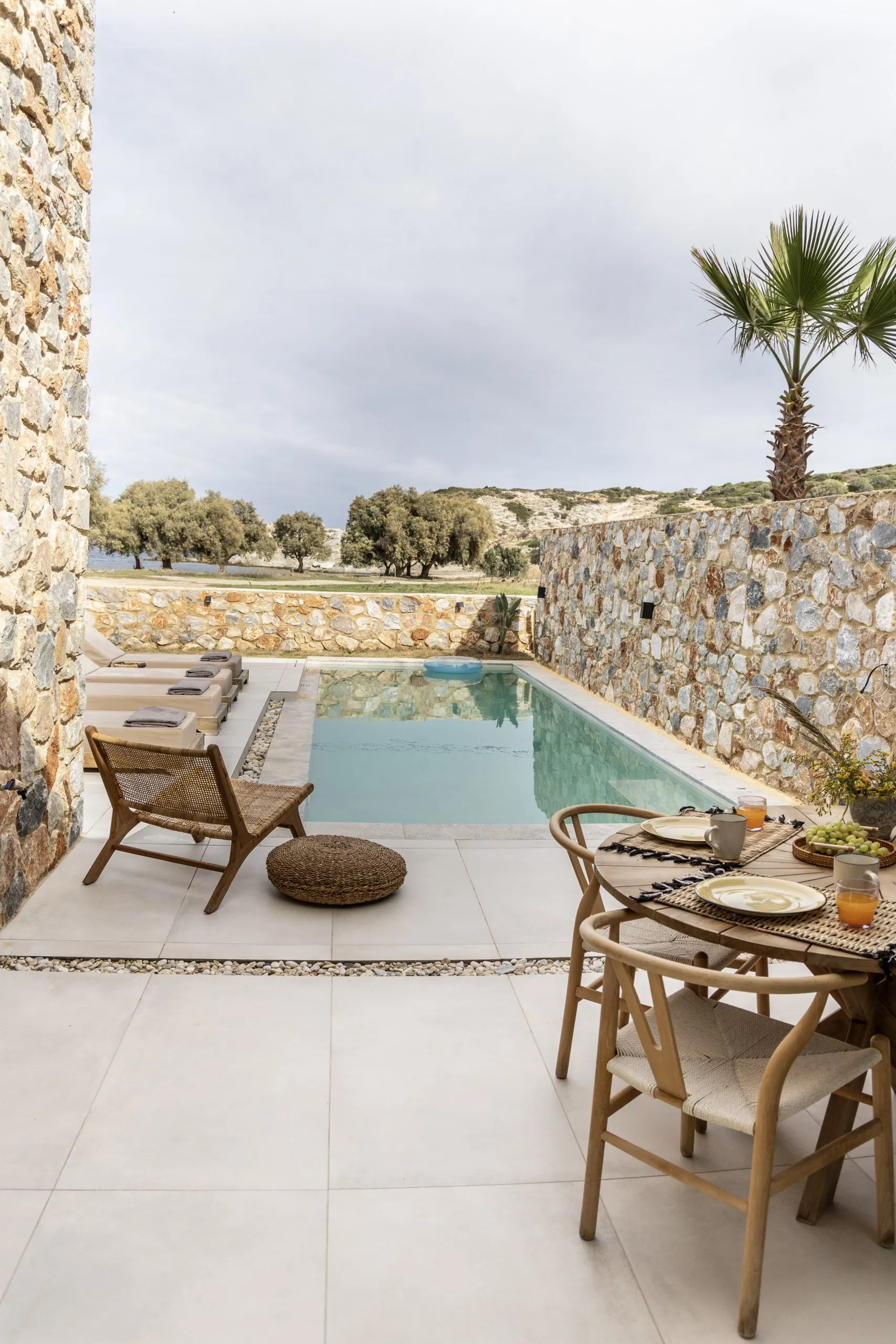 Poolside terrace with rattan chairs at Norte Luxury Villas